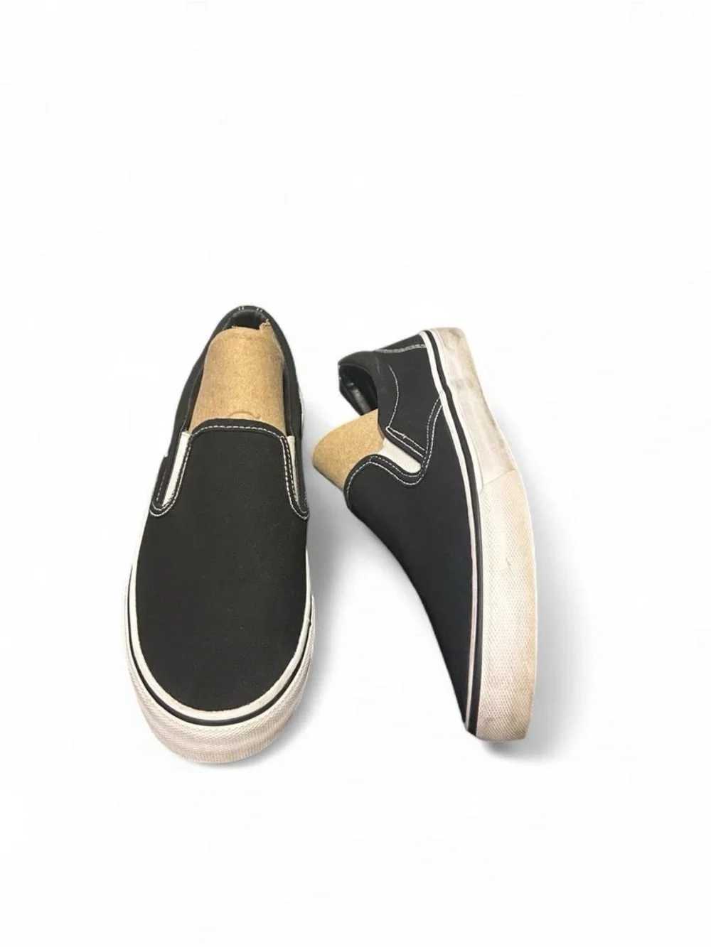 Black slip-on sneakers with white sole and white stitching